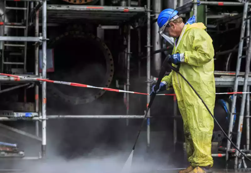operador realizando limpieza química en planta petroquímica